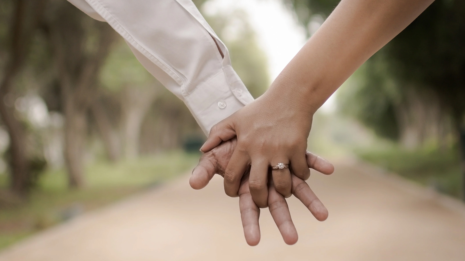 close up on the hands of an engaged couple holding hands